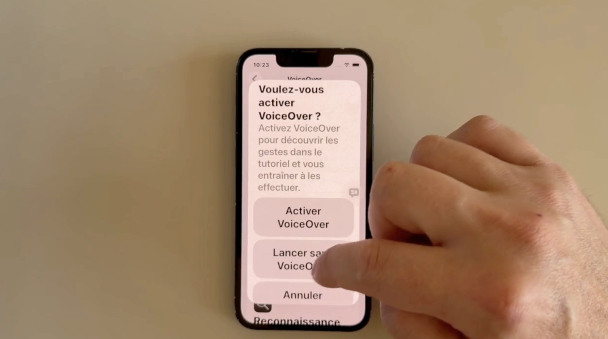 Écran iPhone affichant la question « Voulez-vous activer VoiceOver ? » avec les boutons Activer VoiceOver et Lancer sans VoiceOver.
